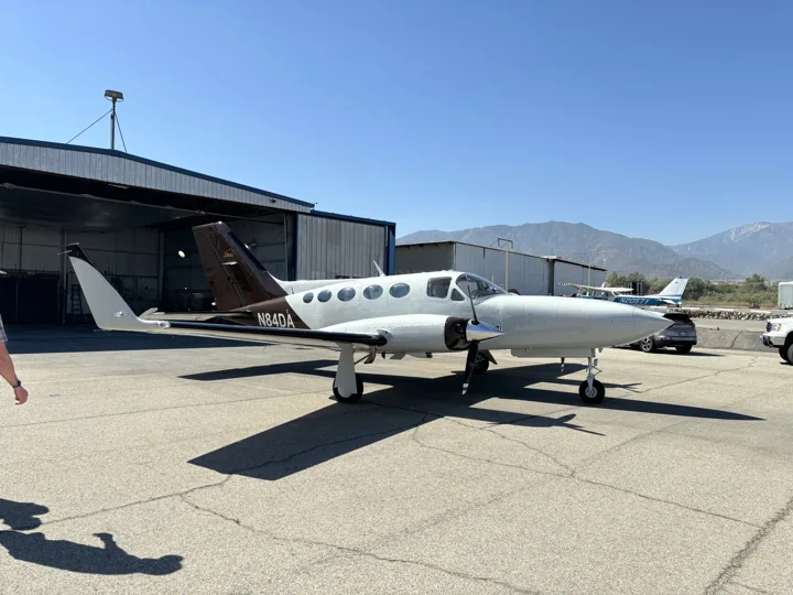 Side view of a white twin-engine aircraft with a contrasting black tail