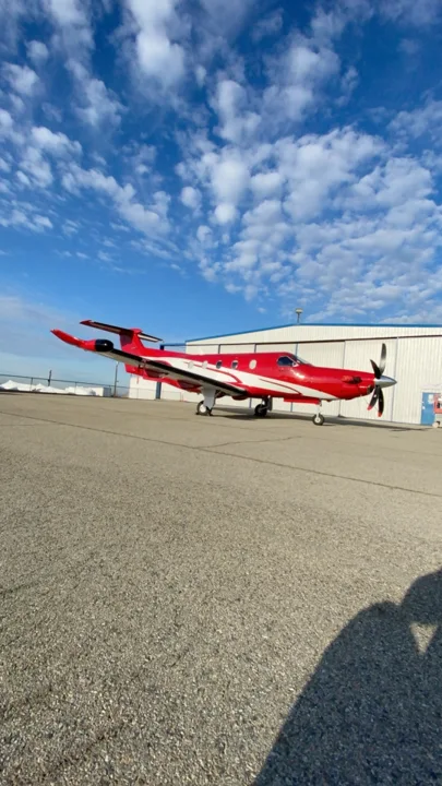 Portrait view of the red and white turboprop under a blue sky